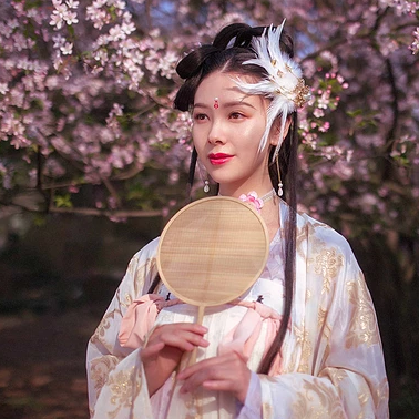 粉色桃花拂面帶團扇女生頭像，唯美古風真人頭