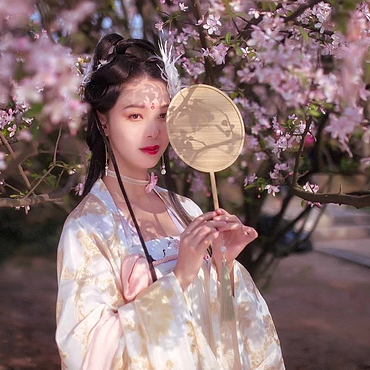 粉色桃花拂面帶團扇女生頭像，唯美古風真人頭